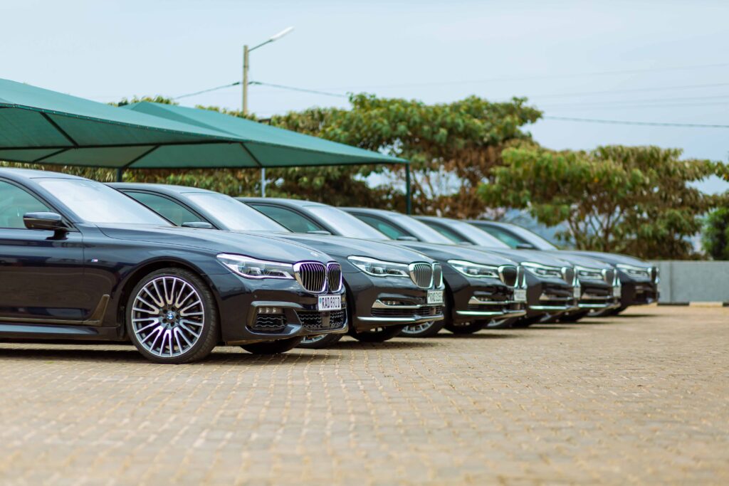 Row of luxury cars parked at an outdoor dealership, showcasing elegance.