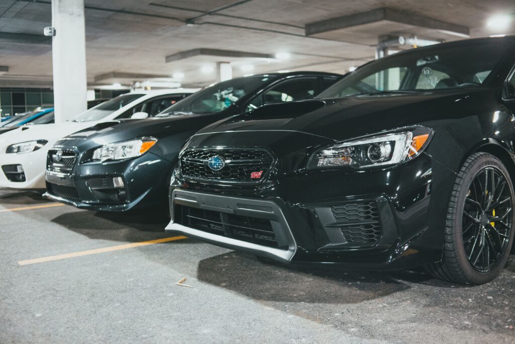 A row of parked Subaru cars in an indoor parking garage, showcasing modern automotive design.